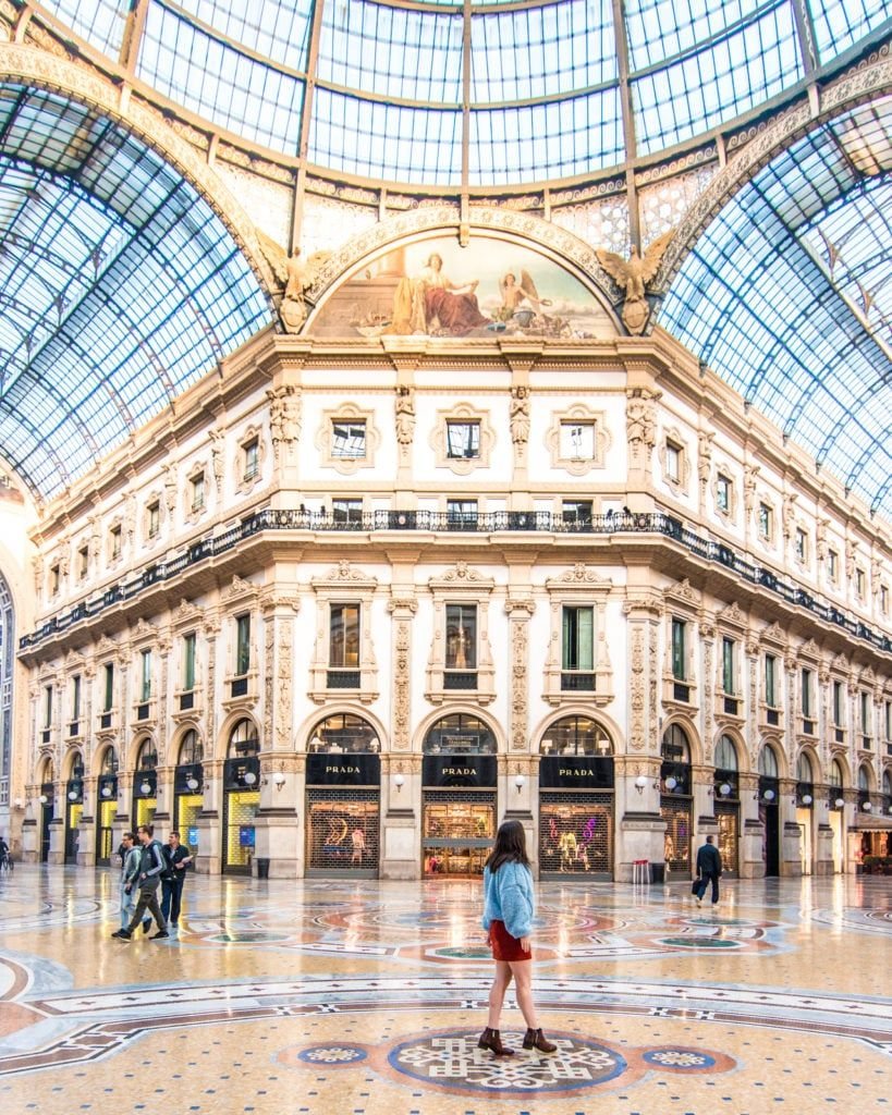 Ornate architecture and luxury Prada storefronts inside the Galleria Vittorio Emanuele II in Milan.